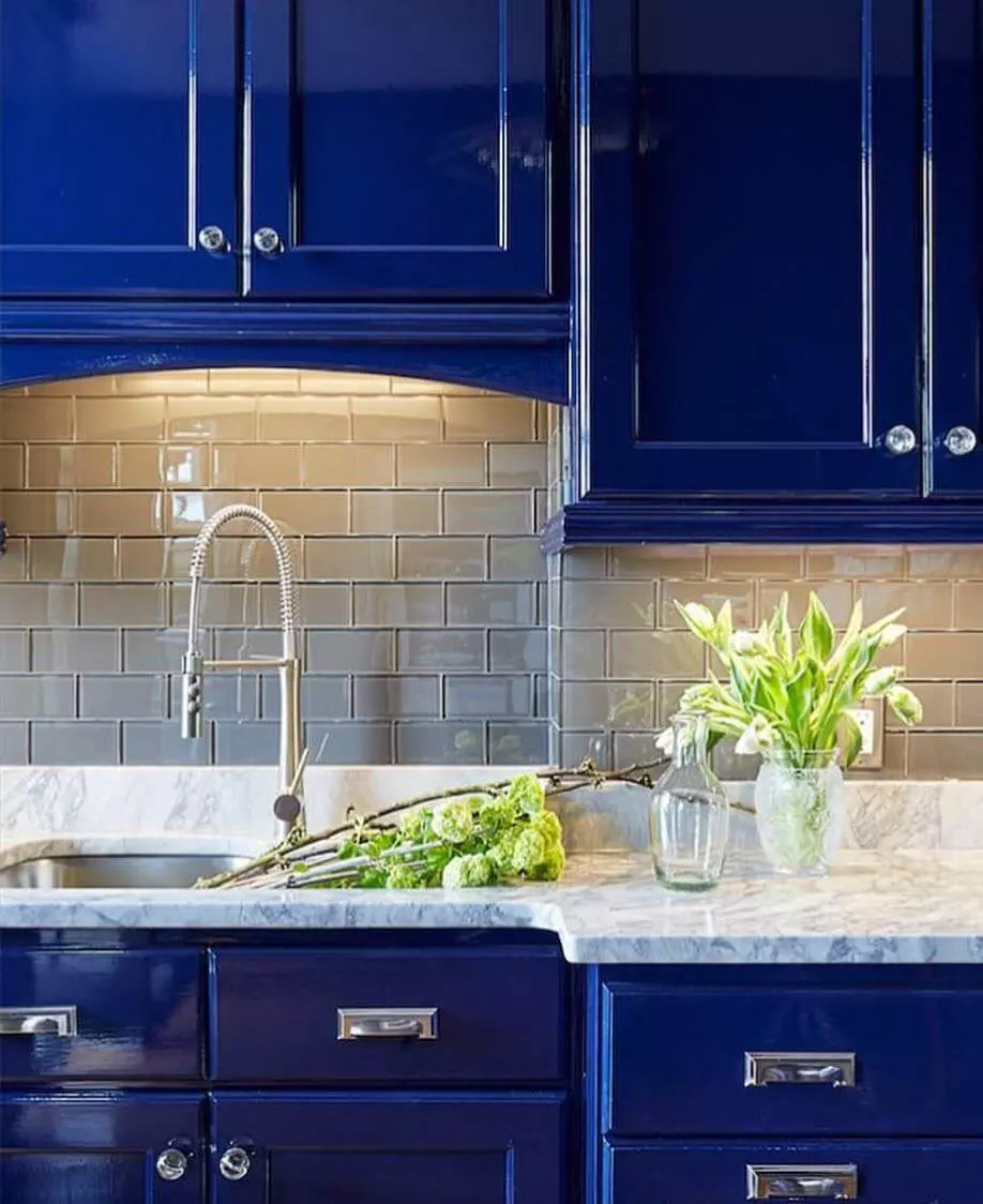 photo of a kitchen sink area with cabinets painted with a high gloss blue paint.