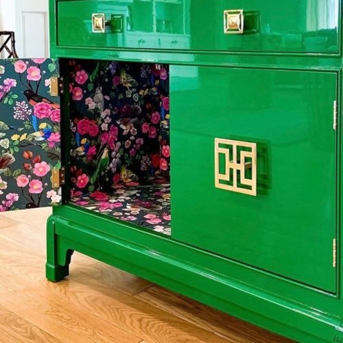 photo of cabinet painted green with high gloss paint, and cabinet door is open showing floral pattern on surface.