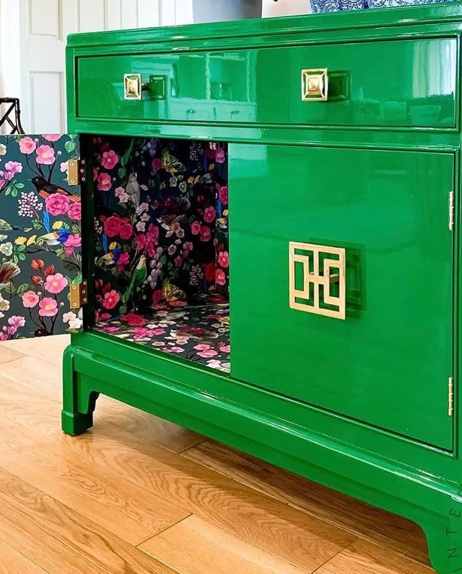photo of cabinet painted green with high gloss paint, and cabinet door is open showing floral pattern on surface.