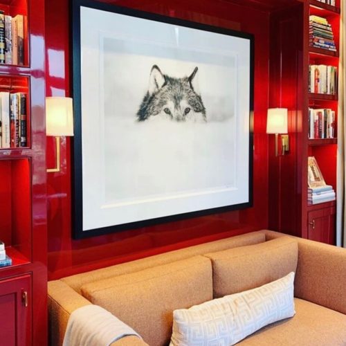 photo of interior room with red high gloss painted walls, art on wall and couch..